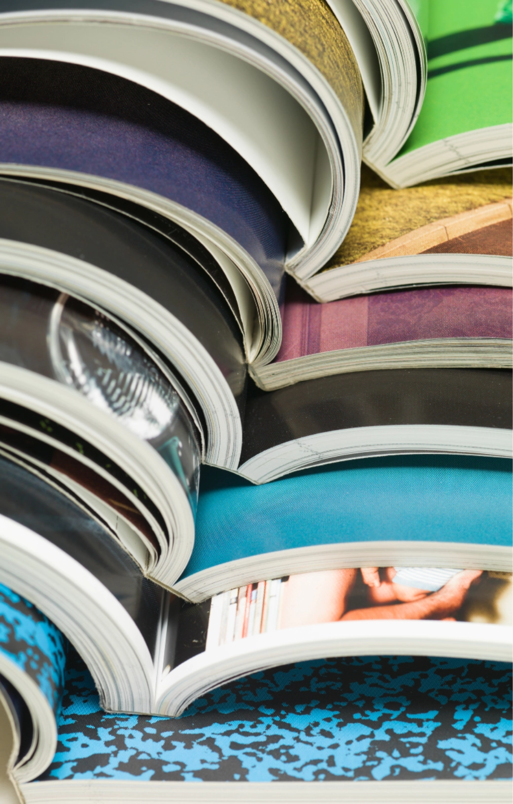 Close up view of stacked open magazines showing colourful printed pages